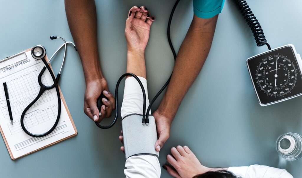 Healthcare professional checking a patient's blood pressure, underscoring the health impacts of food insecurity.