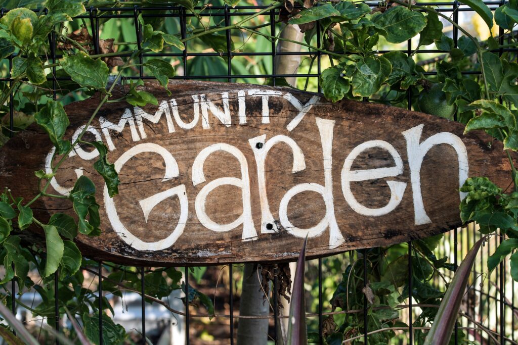 Community garden sign surrounded by greenery, emphasizing the role of community gardens in food security.